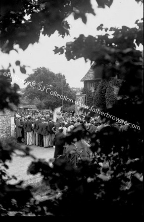 PROCESSION IN VILLAGE STREET THROUGH TREES